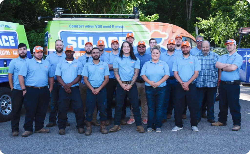 A Group Of Fifteen People In Blue Uniforms And Two In Casual Shirts Stand In Front Of Colorful Service Vans, Ready To Serve The Nashville Community. Perfect For Your Homepage, This Image Captures Teamwork And Dedication At Its Finest.